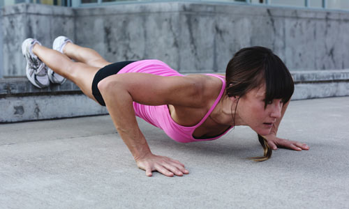 Stærk kvinde der laver push ups